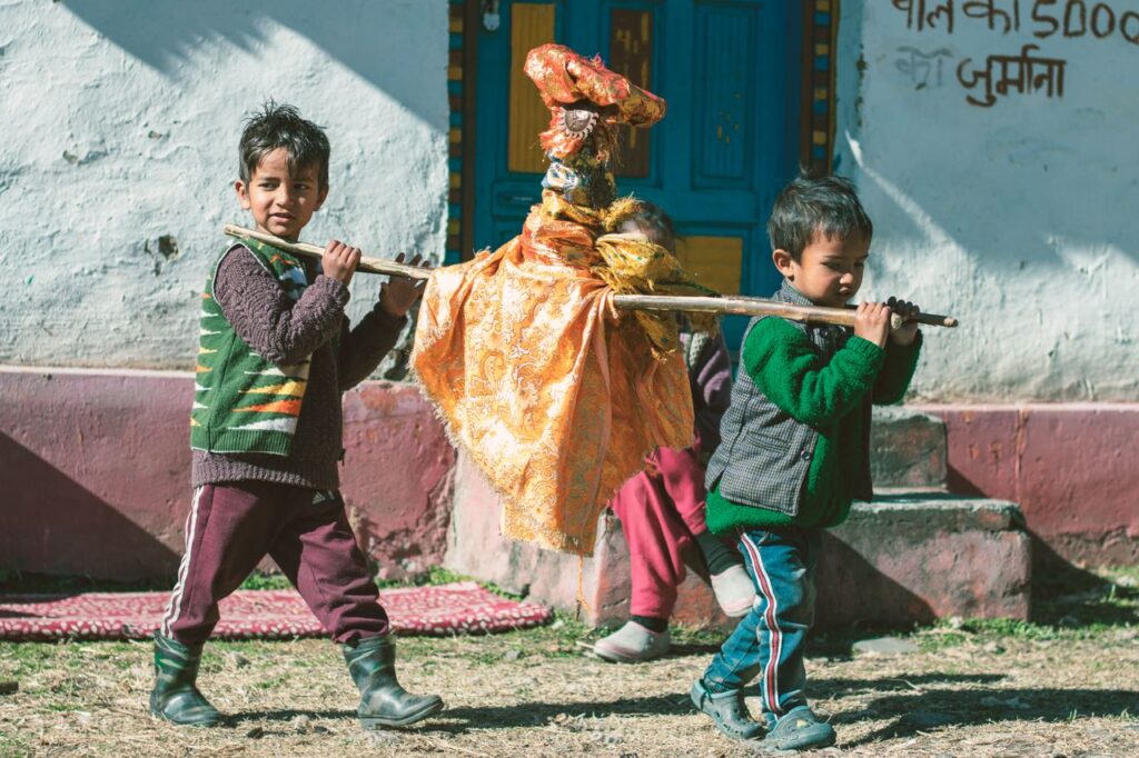 Children carrying a traditional figurine during a festival in Kasol, Himachal Pradesh.