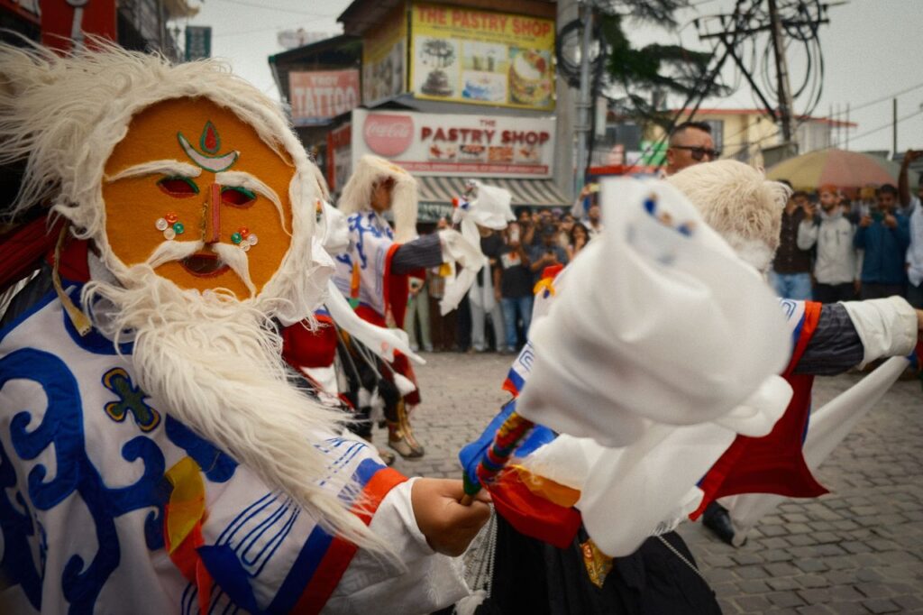 Vibrant traditional Tibetan mask dance during a festival in Dharamshala, Himachal Pradesh, India.
